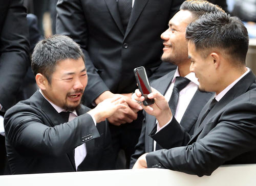 パレード中、泣きっぱなしの田中（左）を撮影する田村（撮影・狩俣裕三）