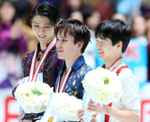 男子フリーの表彰式で優勝した宇野(中央)を見つめてほほ笑む2位の羽生(左)。右は3位鍵山(撮影・垰建太)