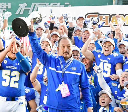 甲子園ボウルを制しトロフィーを掲げる関学大の鳥内監督（撮影・清水貴仁）