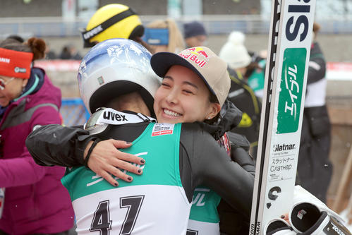 ピンケルニヒ（左手前）の優勝をたたえ笑顔でハグをする5位高梨（撮影・佐藤翔太）