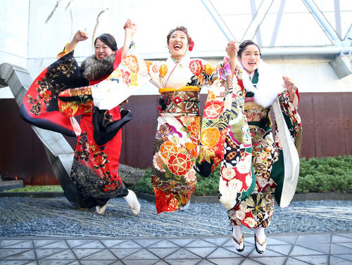 成人式で友人の田中さん（左）と小原さん（右）と一緒に笑顔でジャンプする森（撮影・大野祥一）