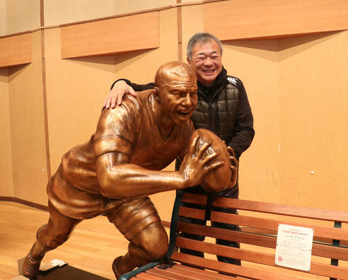 リーチ像の肩に手をやり、満面の笑みを浮かべる札幌山の手・佐藤監督（撮影・浅水友輝）
