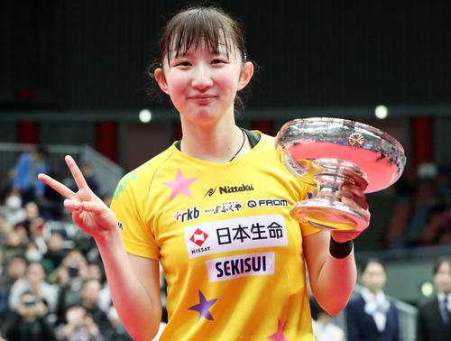 女子シングルスで初優勝し、カップを手にVサインを見せる早田（撮影・加藤哉）