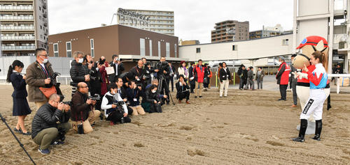 川崎競馬場のコースでミカエル・ミシェル騎手は大勢の報道陣に囲まれる（撮影・柴田隆二）