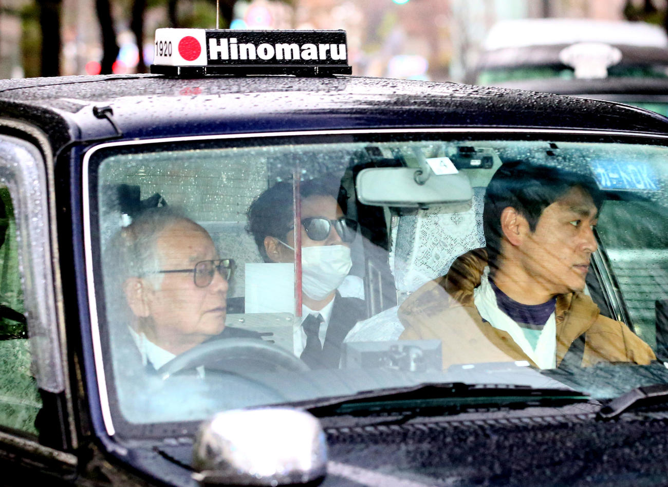 サングラス姿で東京地裁に入る国母被告（中央）（撮影・足立雅史）