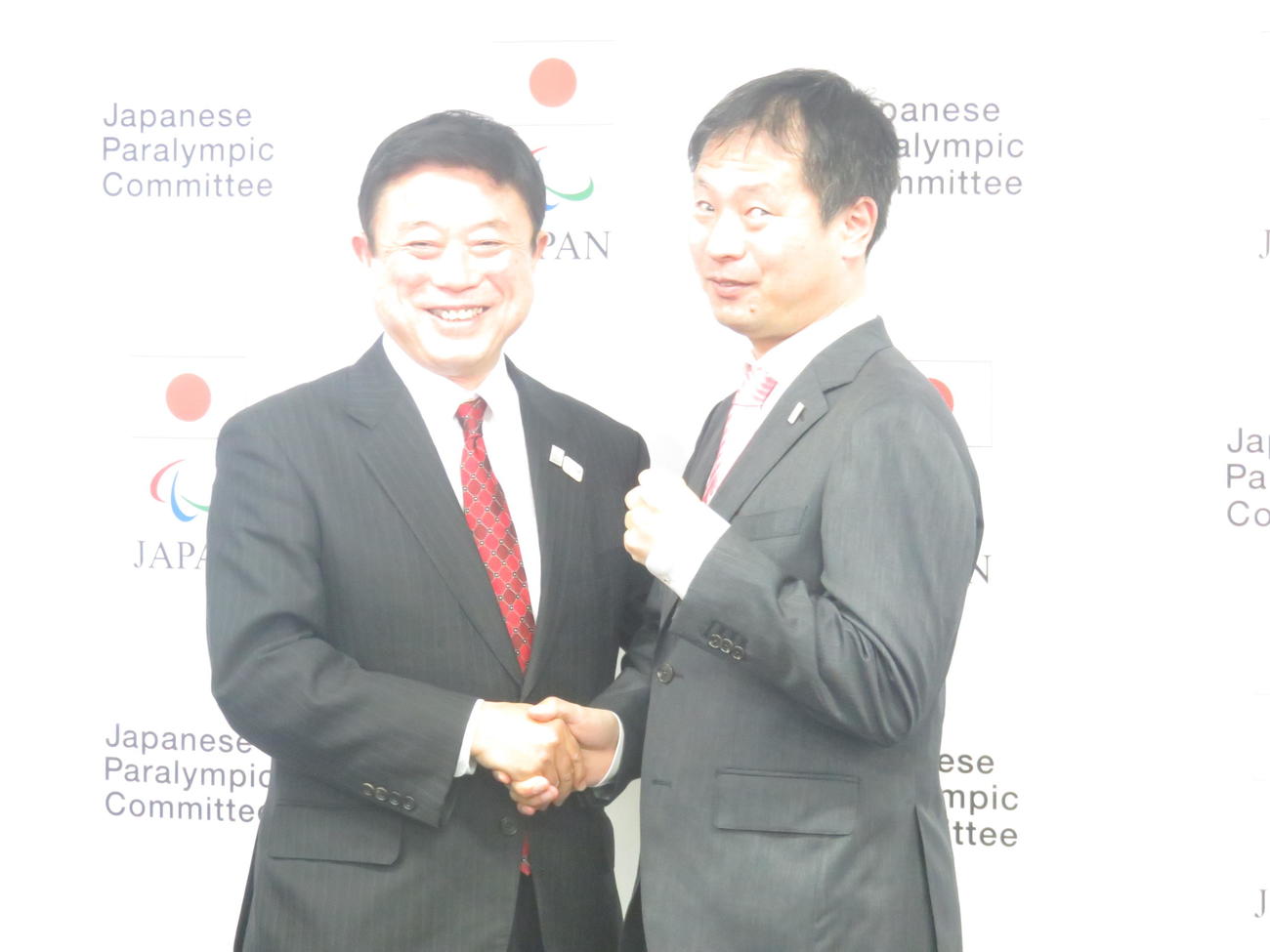 パラリンピックの日本選手団長に就任した河合純一氏（右）は日本障がい者スポーツ協会常務理事、JPC副委員長の高橋秀文氏とガッチリ握手（撮影・小堀泰男）