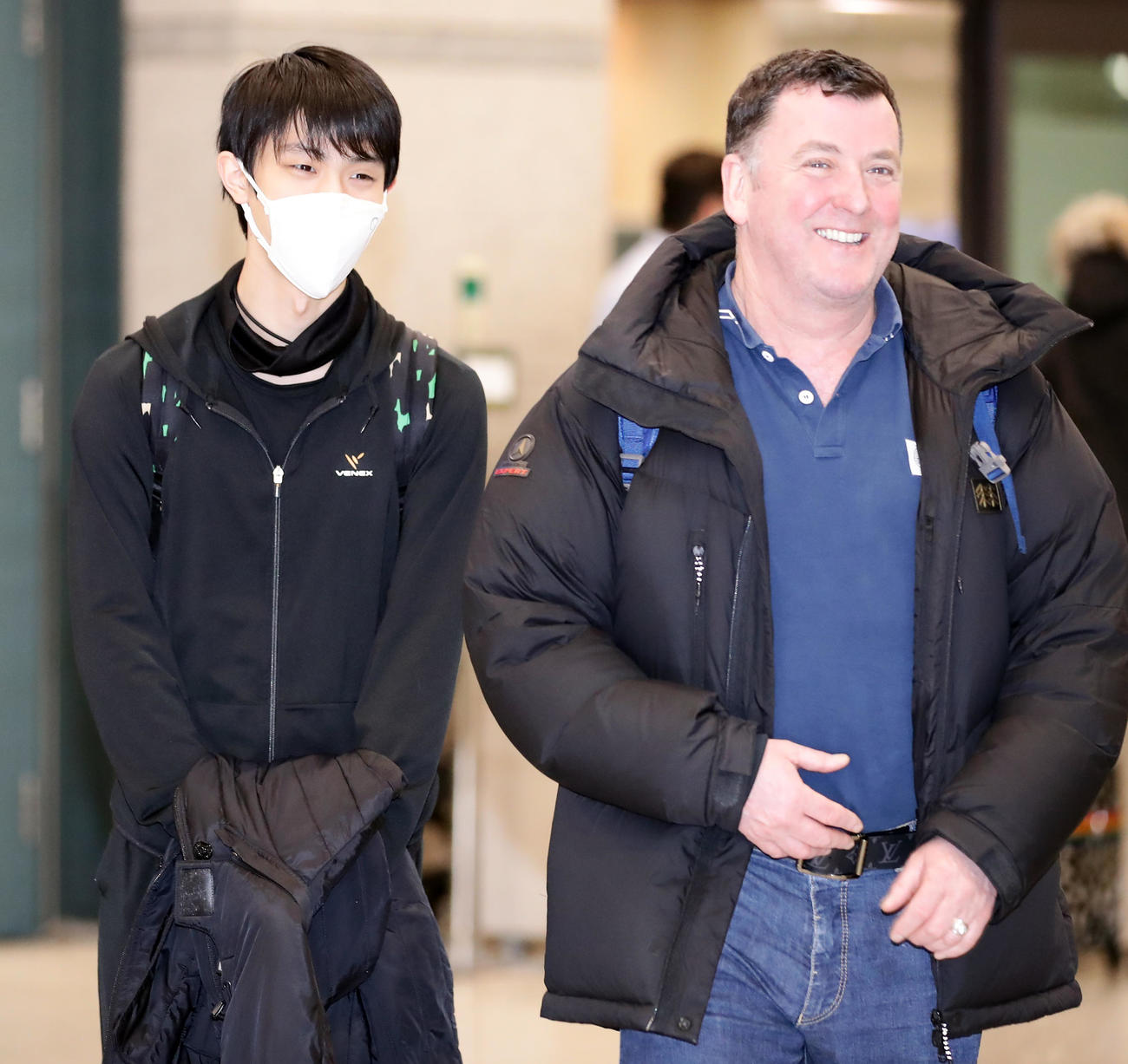 マスク姿でオーサーコーチ（右）と談笑しながら韓国の仁川国際空港に到着した羽生（撮影・浅見桂子）