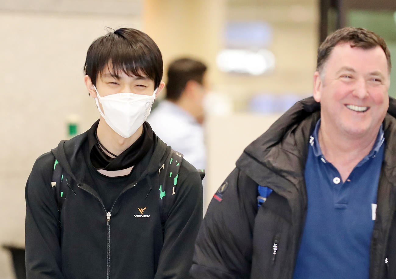マスク姿でオーサーコーチ（右）と談笑しながら韓国の仁川国際空港に到着した羽生（撮影・浅見桂子）