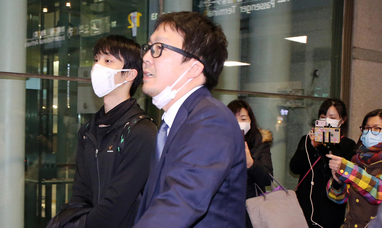 韓国の仁川国際空港に到着した羽生は、集まったファンから守られて車に向かう（撮影・浅見桂子）