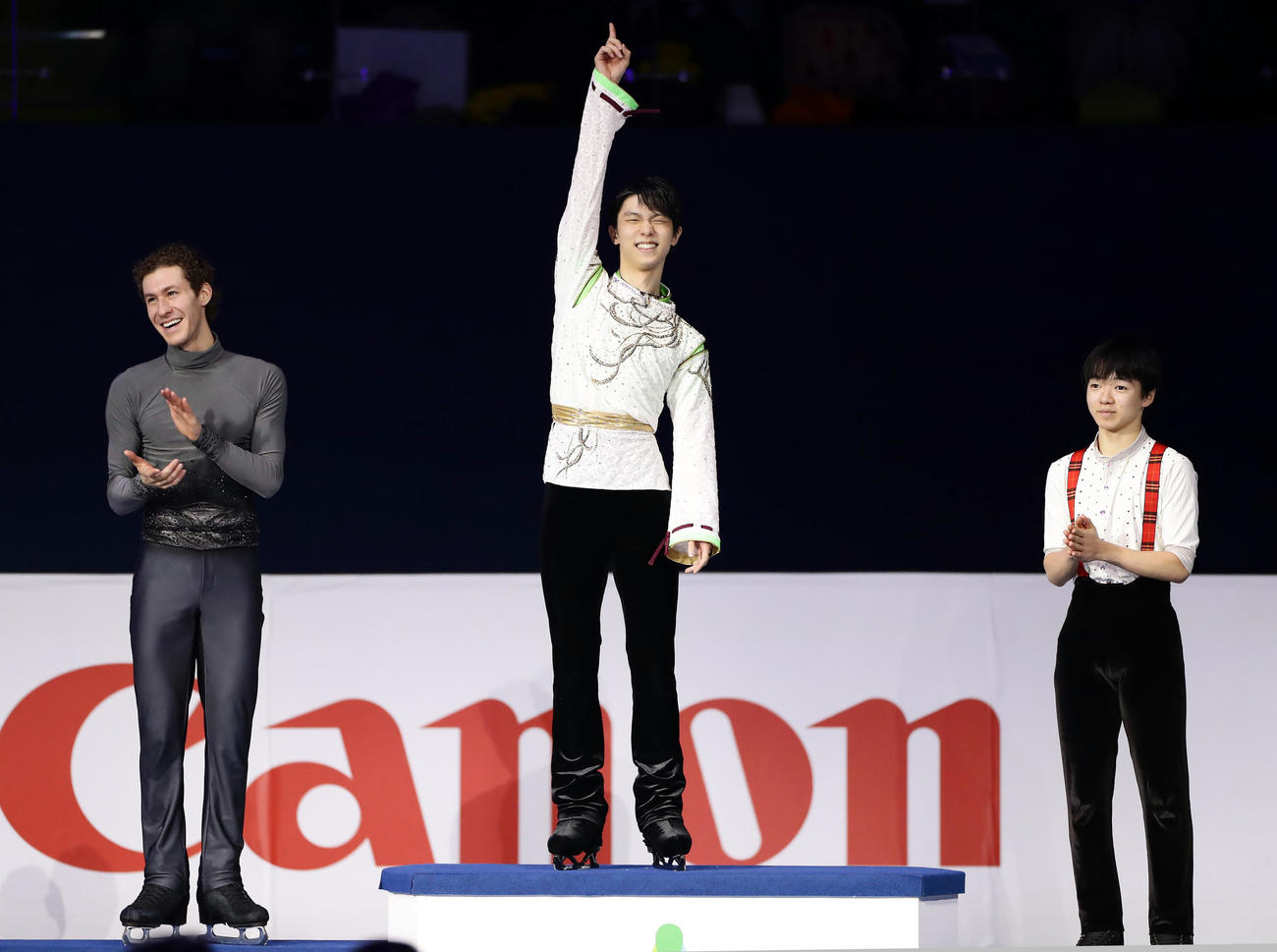 初優勝を決めた羽生（中央）は、表彰台に登ると指を突き上げ笑顔を見せる。左はジェイソン・ブラウン。右は鍵山（撮影・浅見桂子）