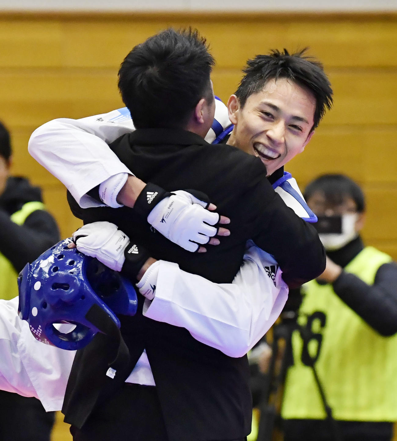 男子58キロ級で東京五輪日本代表に決まり、笑顔で関係者と抱き合う鈴木セルヒオ（共同）
