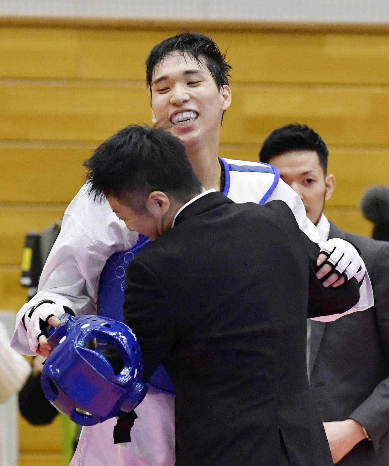男子68キロ級で東京五輪日本代表に決まり、笑顔で関係者と抱き合う鈴木リカルド（共同）