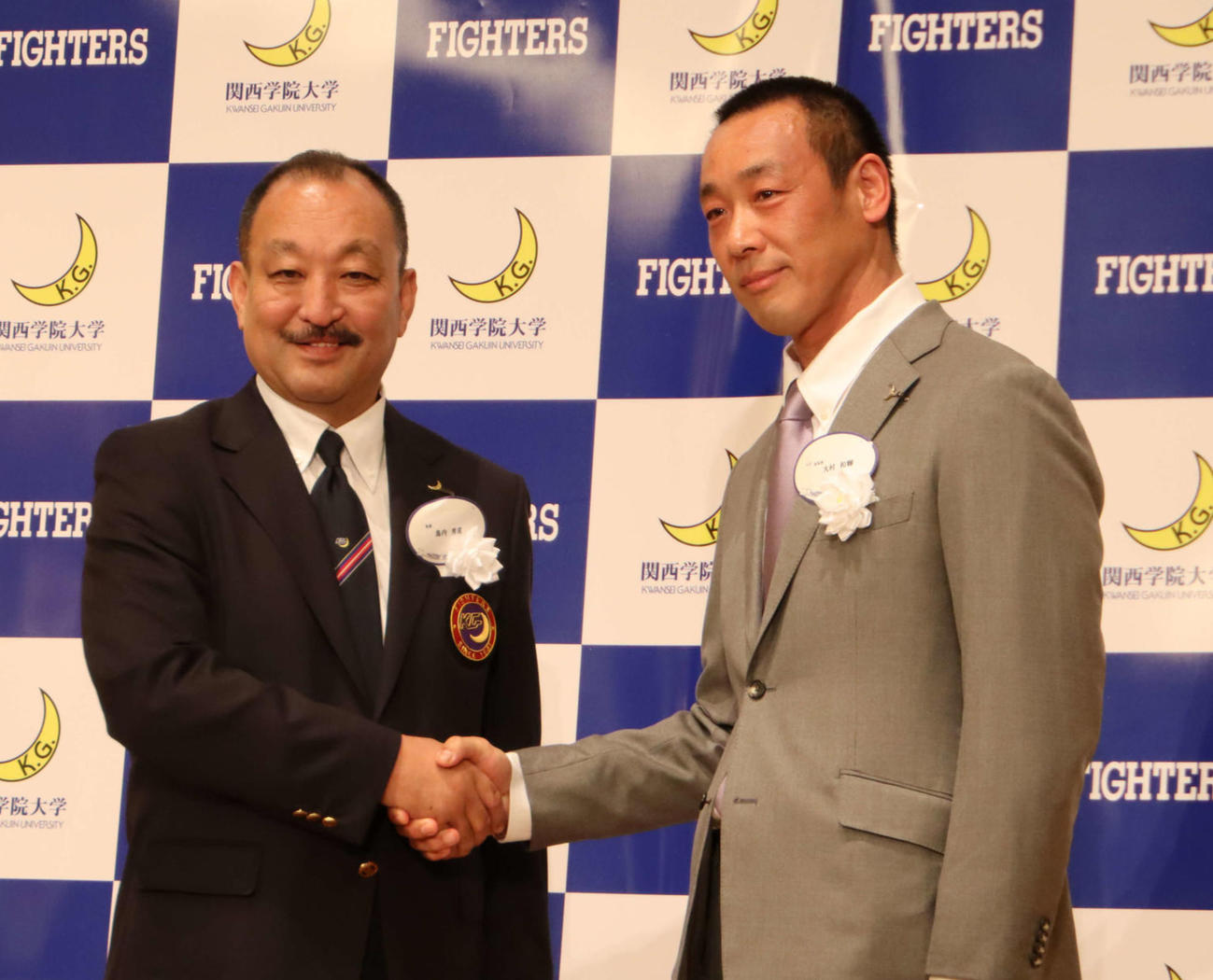 祝賀会で握手を交わす鳥内氏（左）と大村新監督（撮影・南谷竜則）
