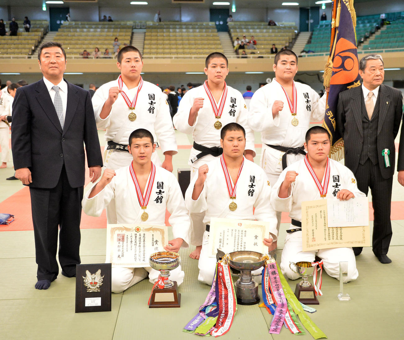 男子団体決勝で優勝し記念撮影する国士舘岩渕監督（左）と選手たち（2015年3月21日撮影）