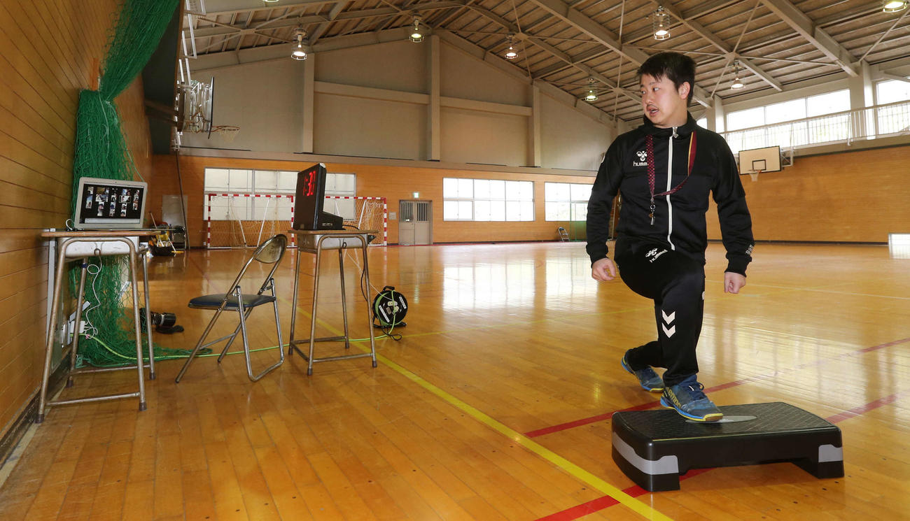 パソコン（左端）内蔵のカメラに向かって、自ら運動動作の手本を示して生徒に教示する中村監督（撮影・野上伸悟）