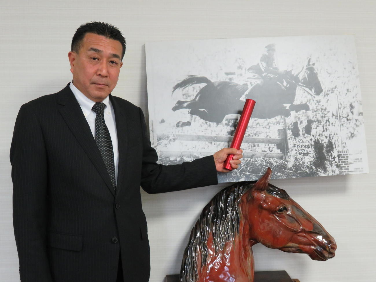 写真パネル（中央）は馬術競技でただひとりの日本人メダリストのバロン西こと西竹一氏、左は尾辻勝馬事公苑苑長（2018年3月27日撮影）