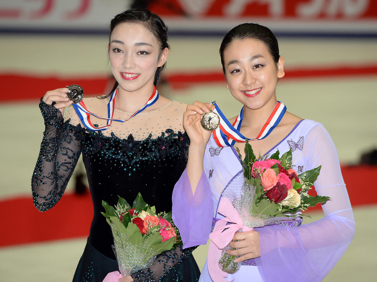 15年中国杯を制した浅田真央（右）は2位の本郷理華と一緒に笑顔を見せる（2015年11月7日撮影）