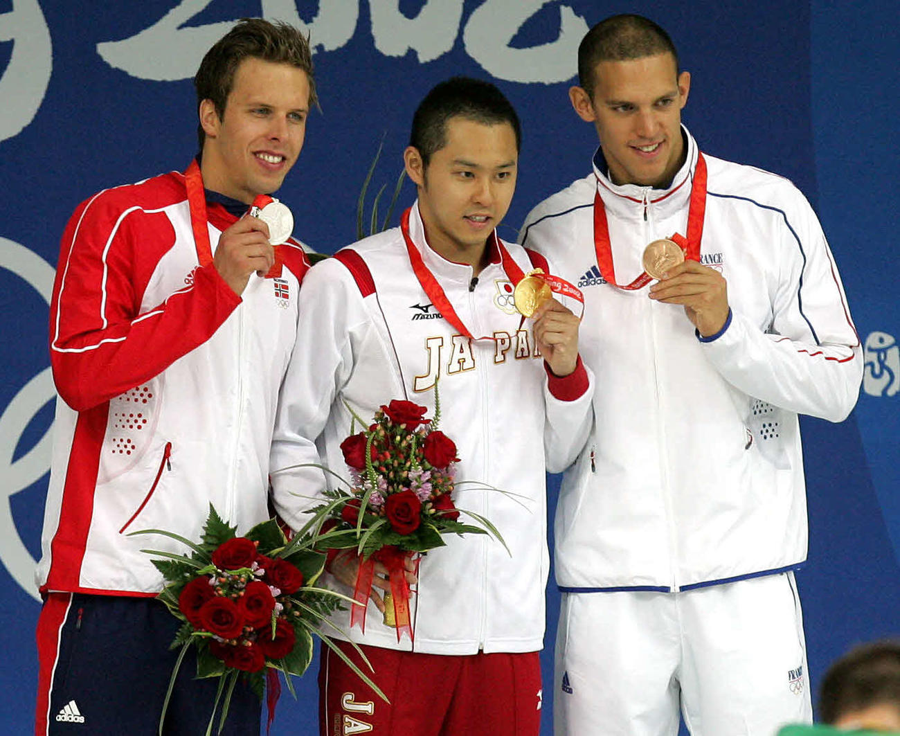 08年8月、北京五輪競泳男子100メートル平泳ぎ表彰式　金メダルを手に笑顔の北島康介　左は2位のノルウェーのダーレオーエン、右は3位のフランスのユーグ・デュボス