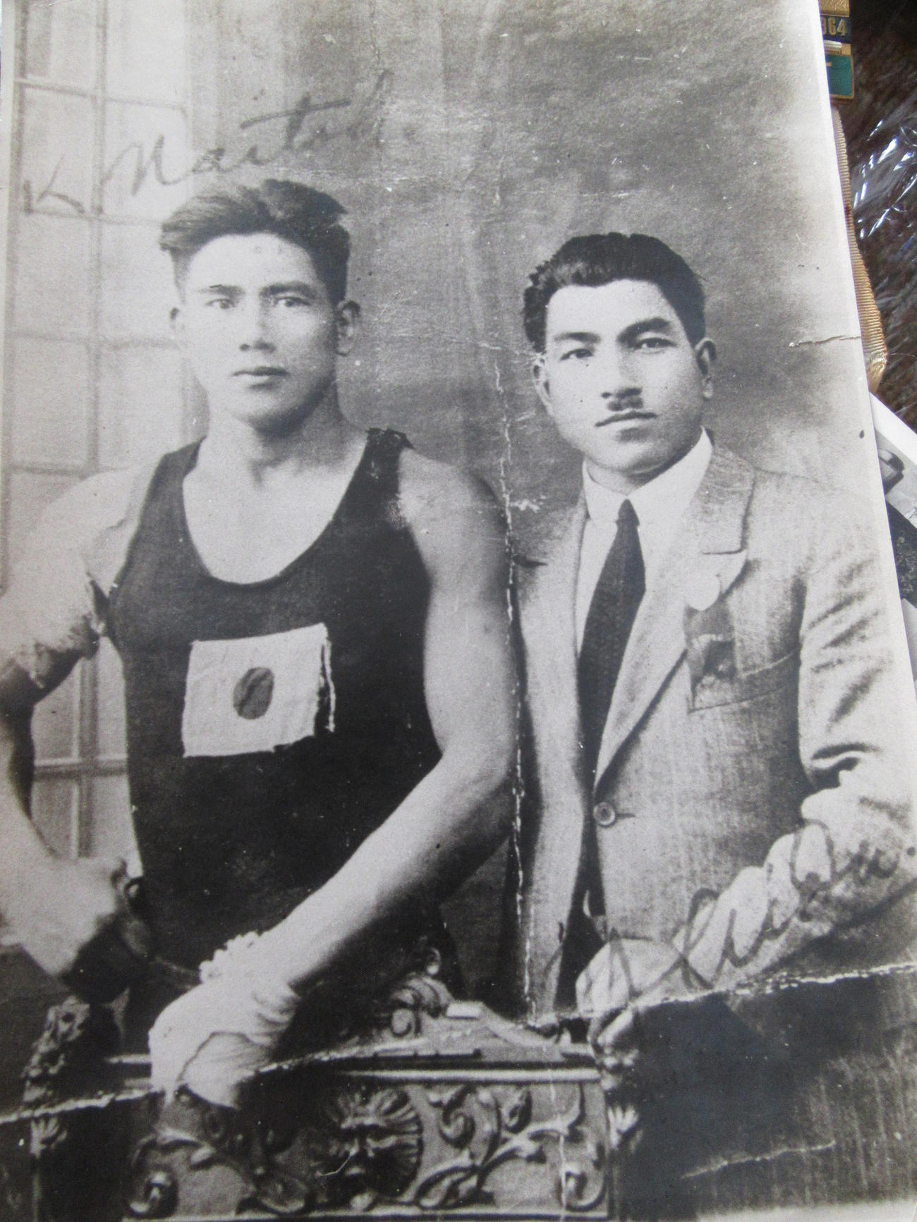 胸の日の丸が裂け、左手と右肩の包帯が痛々しいパリ五輪試合直後の内藤克俊氏（左）。右は講道館五段で欧州で柔道指導中だった会田彦一氏
