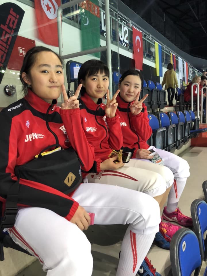 昨年4月の世界カデ選手権でチームメートと笑顔を見せる尾崎（中央）（日本フェンシング協会提供）