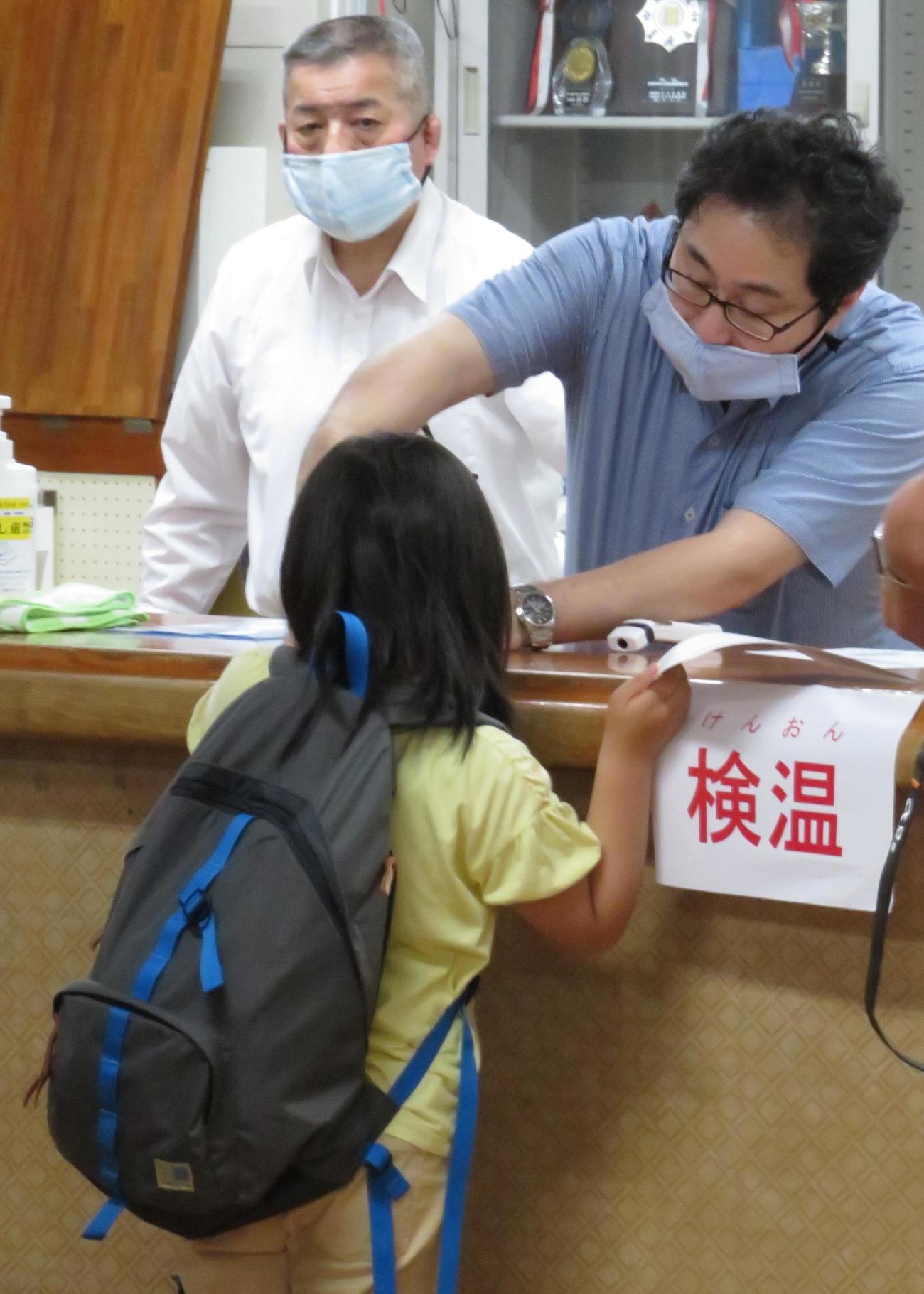 稽古前、講道館の受付で検温する小学生（撮影・峯岸佑樹）