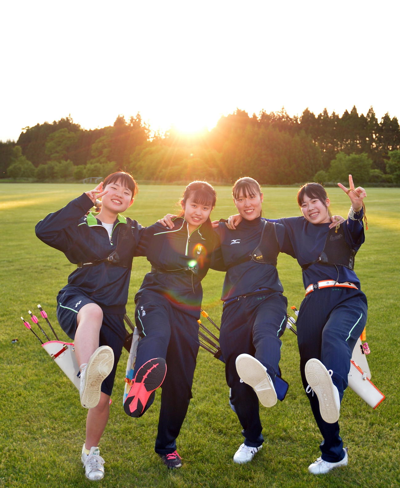 夕日をバックにポーズをとる七戸の3年生女子。左から小舘、久保田、中岫、和田（2020年5月29日撮影）