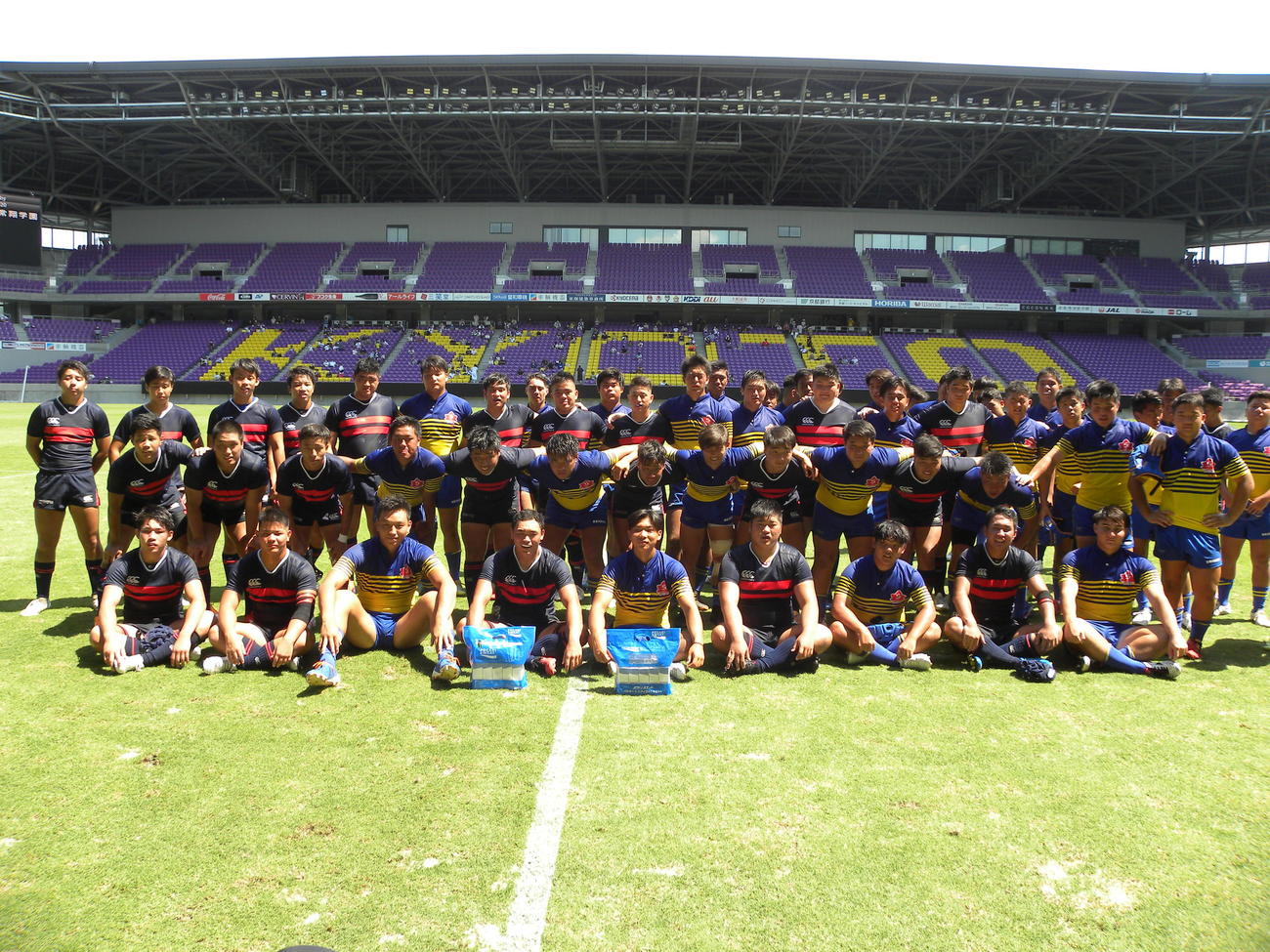 サンガスタジアムbyKYOCERAで記念写真に収まる黄と青のジャージーの京都成章、常翔学園の選手たち（撮影・松本航）