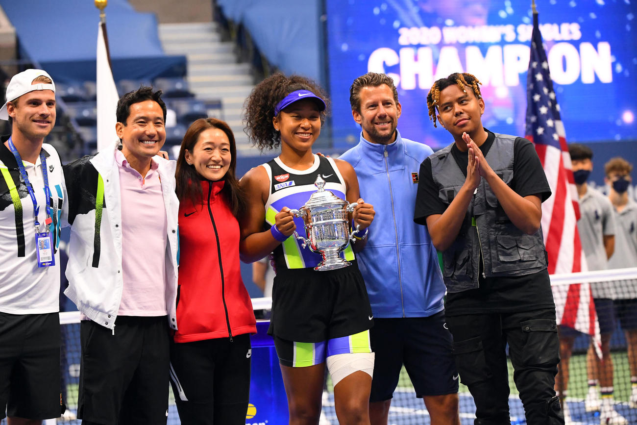 笑顔で優勝トロフィーを掲げる大坂（中央）（USA　TODAY＝ロイター）