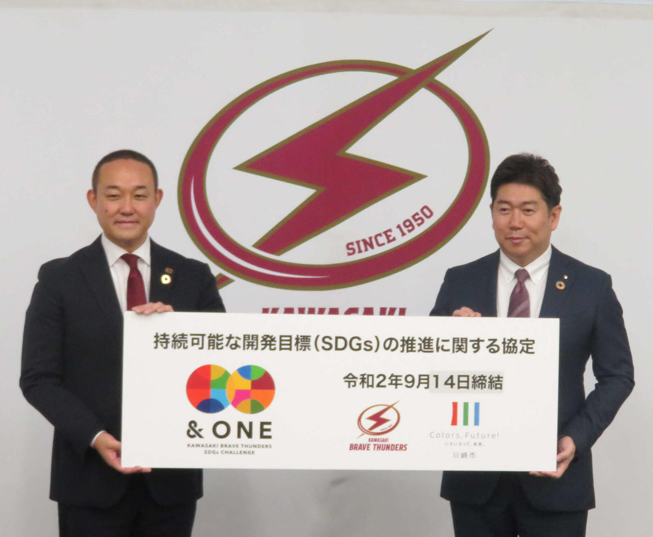 「持続可能な開発目標（SDGs）の推進に関する協定」を締結し、撮影に応じるBリーグB1川崎の元沢伸夫社長（左）と福田紀彦川崎市長