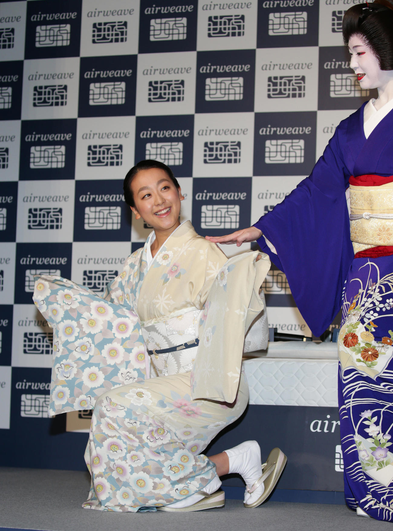 CMで挑戦した京舞の所作を披露する浅田真央。右は京都祗園芸妓（げいこ）「祗をん」の真生さん（2015年5月28日）