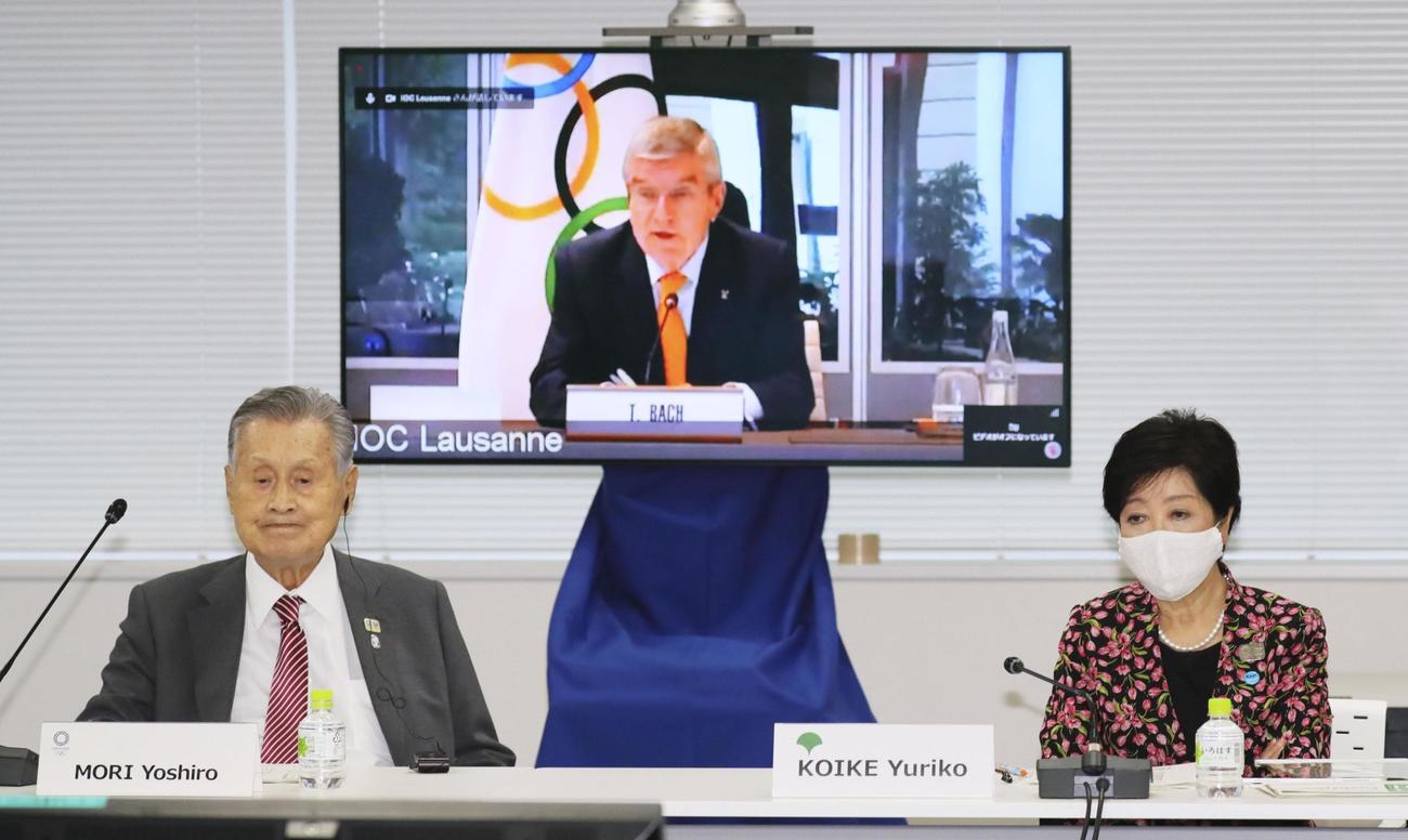 オンライン形式で行われた合同会議であいさつするIOCのバッハ会長（奥）。手前左は東京五輪・パラリンピック組織委員会の森喜朗会長、同右は東京都の小池百合子知事（共同）