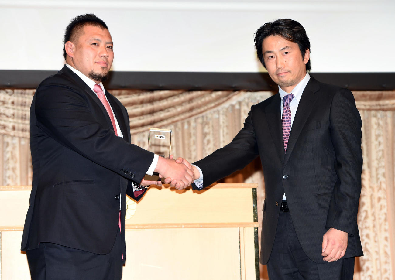 トップリーグ公式アプリ賞スクラム部門で表彰される東芝の湯原祐希さん。右は加藤善彦データスタジアム社長（2015年2月2日撮影）