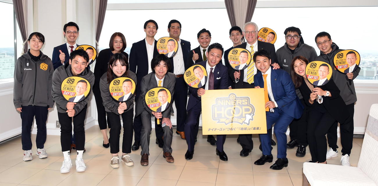 来仙したBリーグ島田チェアマン（前列右から3人目）を囲んで記念撮影するB2仙台志村社長（同右2人目）らスタッフたち（撮影・山田愛斗）