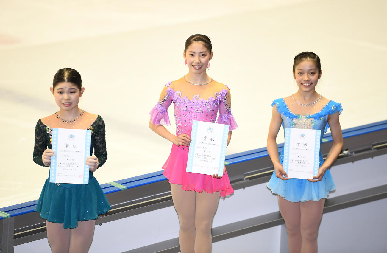 ジュニア女子で優勝し、表彰式で笑顔を見せる住吉りをん（中央）。左は2位の元栄愛子、右は3位の穂積乃愛（代表撮影）