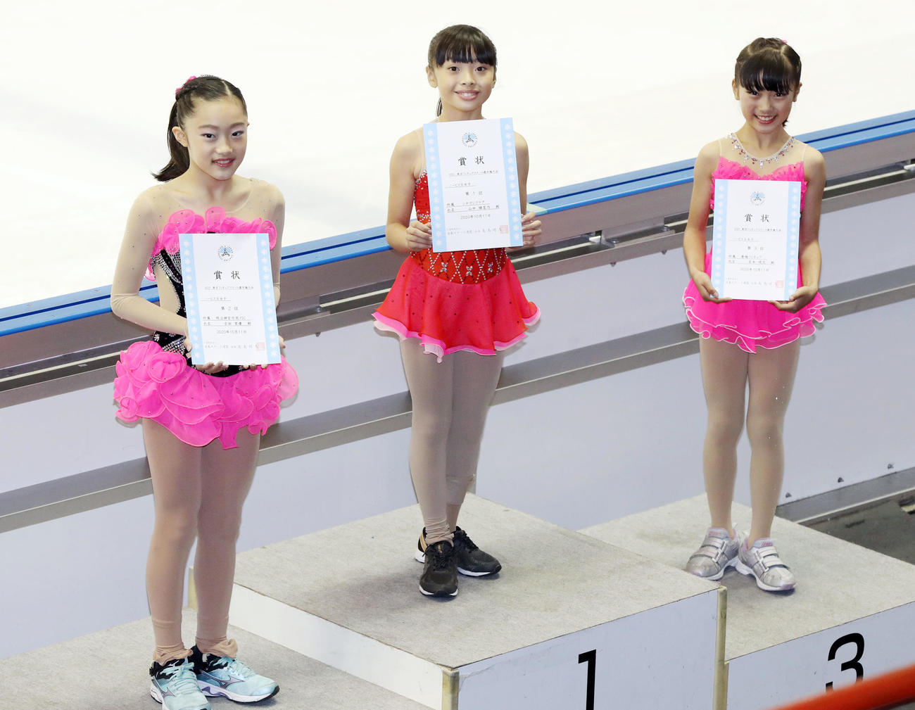 ノービスB女子の表彰式で笑顔を見せる優勝した山中（中央）。左は2位の吉田、右は3位の宮本（撮影・狩俣裕三）