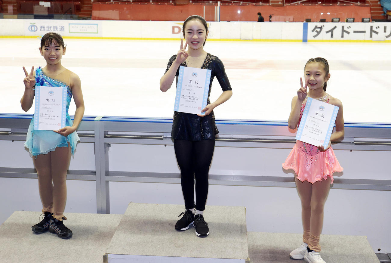 ノービスA女子の表彰式で記念撮影をする優勝した高木（中央）。左は2位の今関、右は3位の新井（撮影・狩俣裕三）