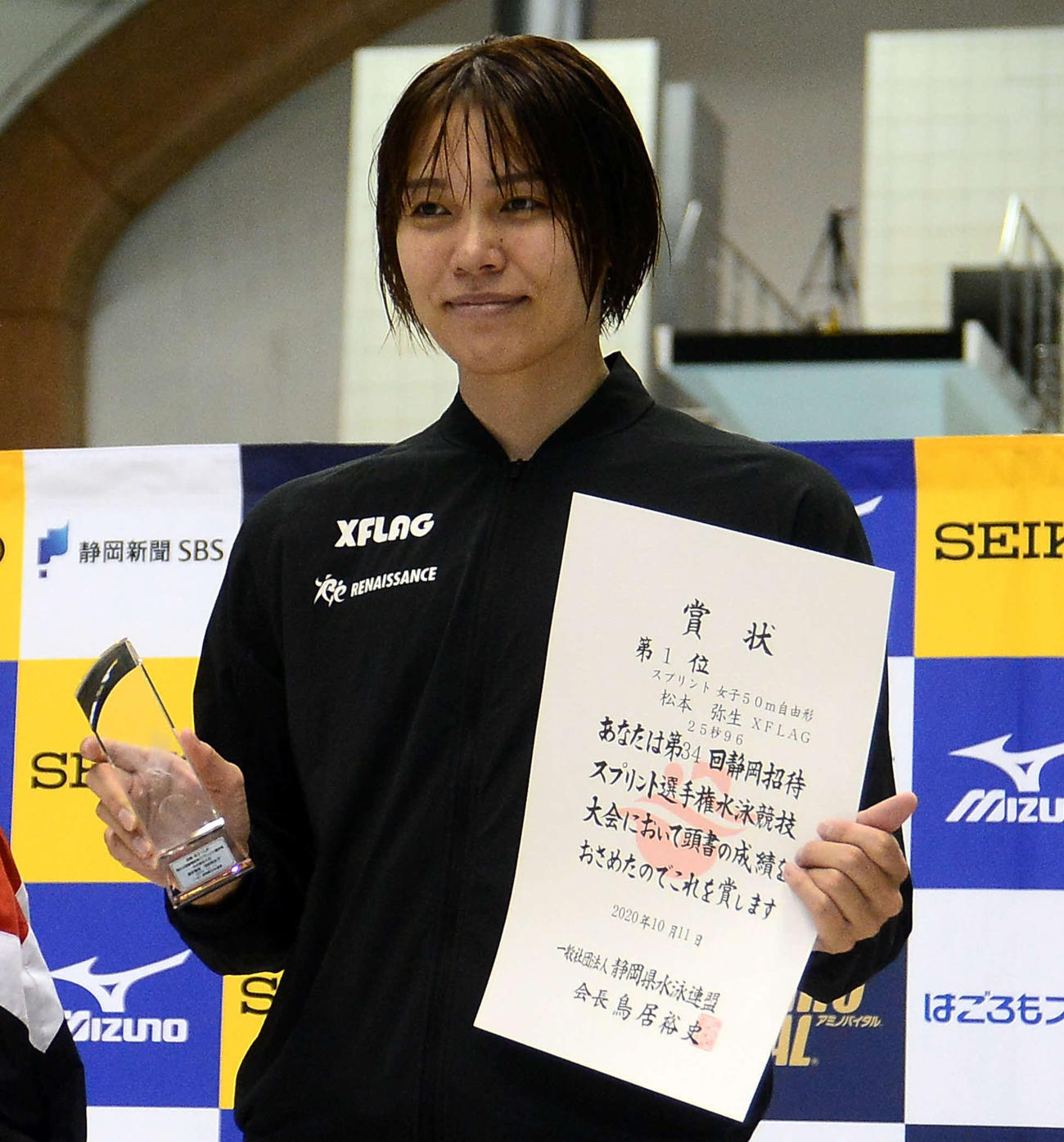 女子50メートル自由形で優勝した松本は、表彰台で笑顔を見せる