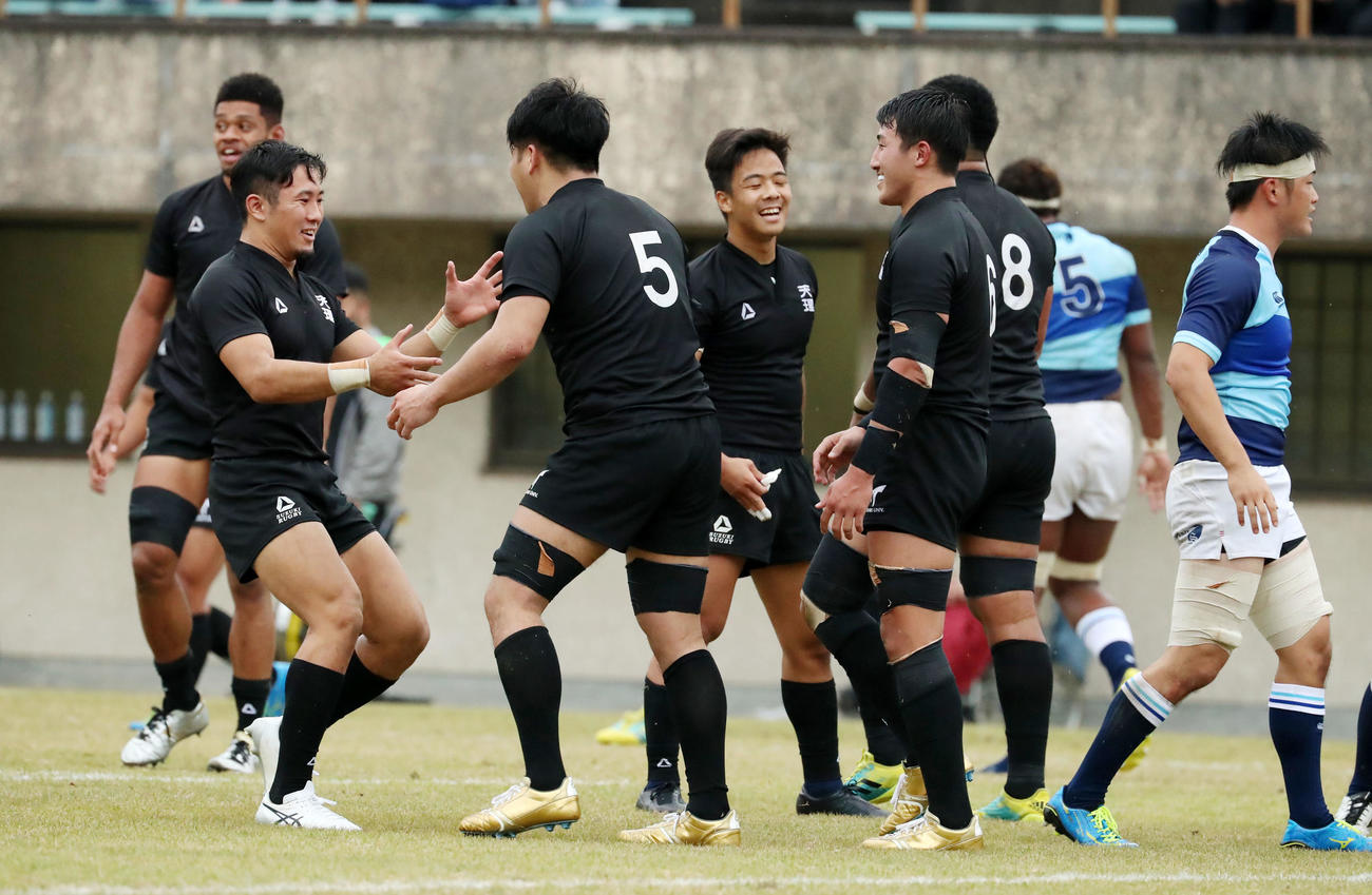 天理大対摂南大　後半、天理大右ロック中鹿が左へトライを決め笑顔で駆け寄るフィフティーンたち（撮影・加藤哉）