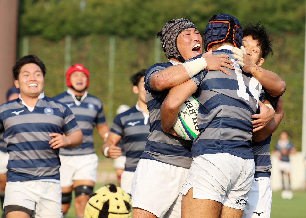 関大対同大　後半、同大WTB岡野（右から2人目）が逆転トライを決め笑顔で駆け寄るフィフティーンたち（撮影・加藤哉）
