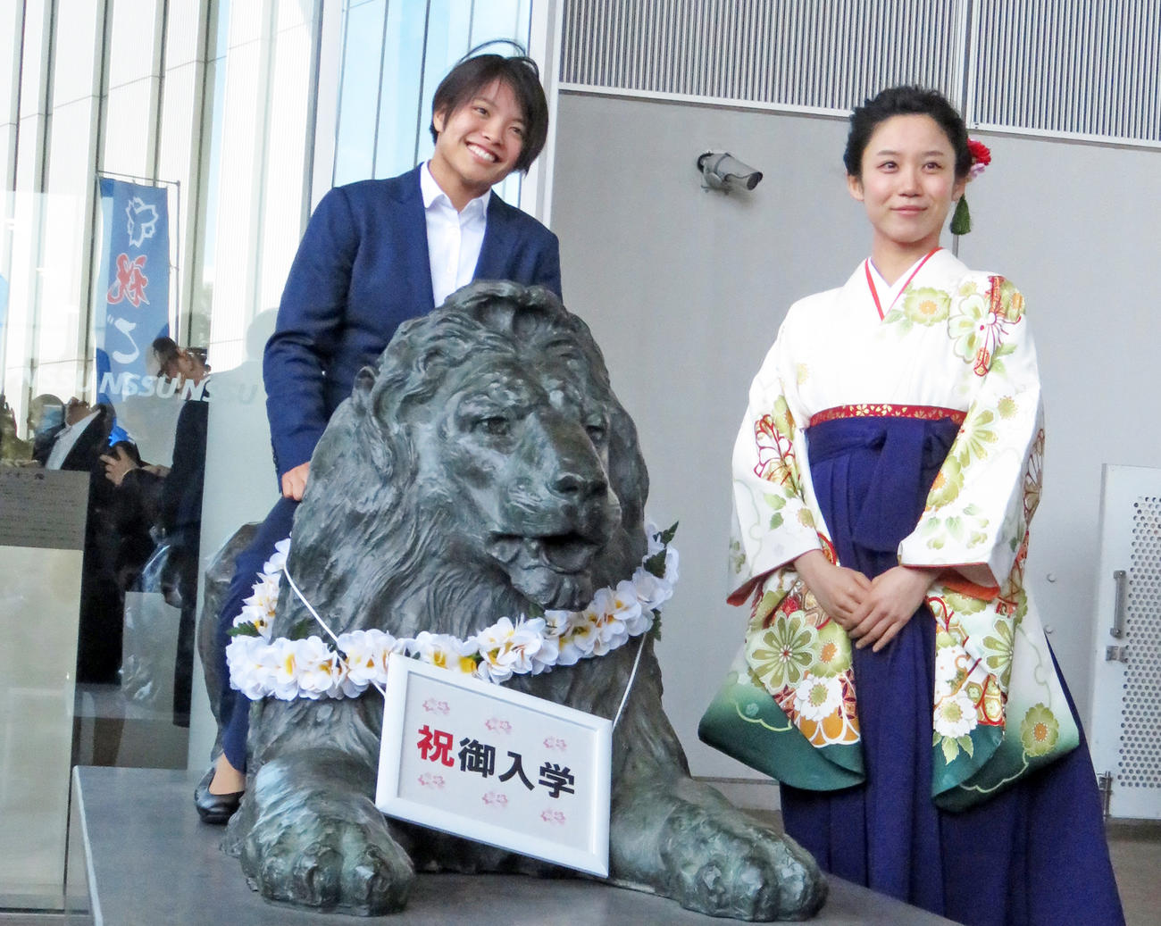 入学式後、ライオン像にまたがる阿部詩と高木美帆（右）（撮影・峯岸佑樹）