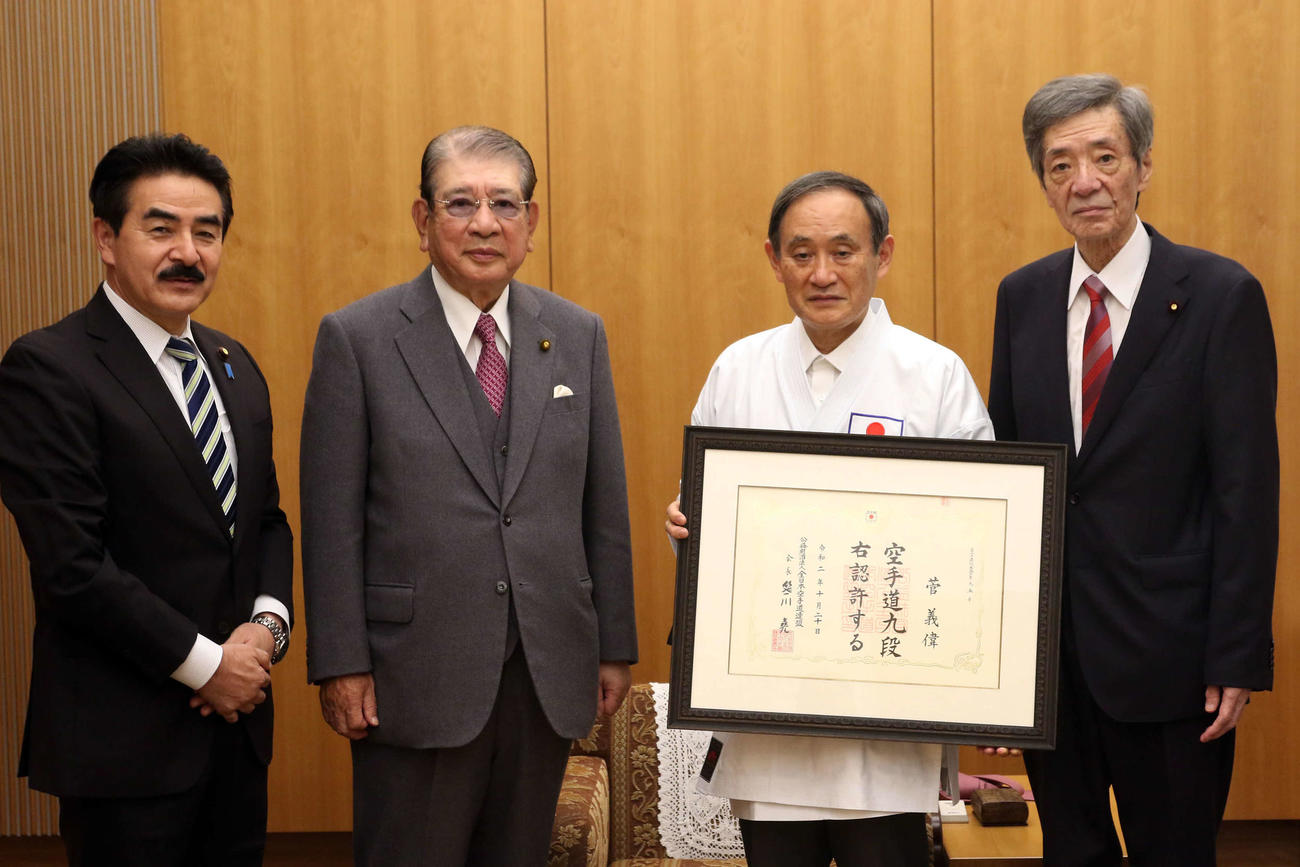 公認段位証を手にして記念写真に収まる菅義偉首相（右から2人目）＝（公財）全日本空手道連盟提供