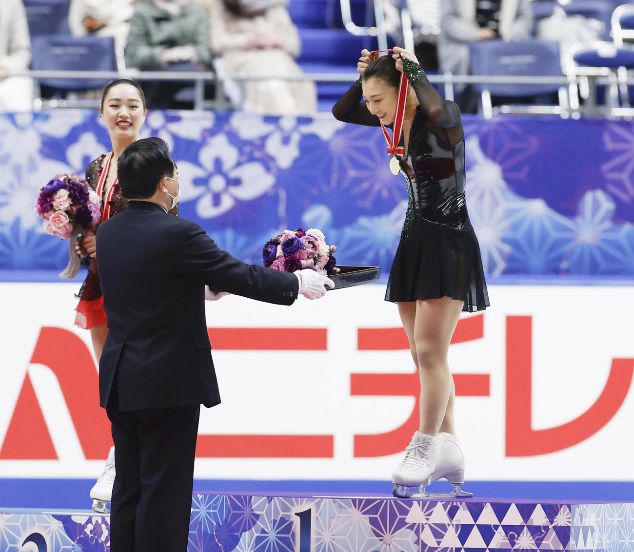 感染症予防のため、自らメダルを手に取り、首にかける優勝した坂本花織（右）（代表撮影）