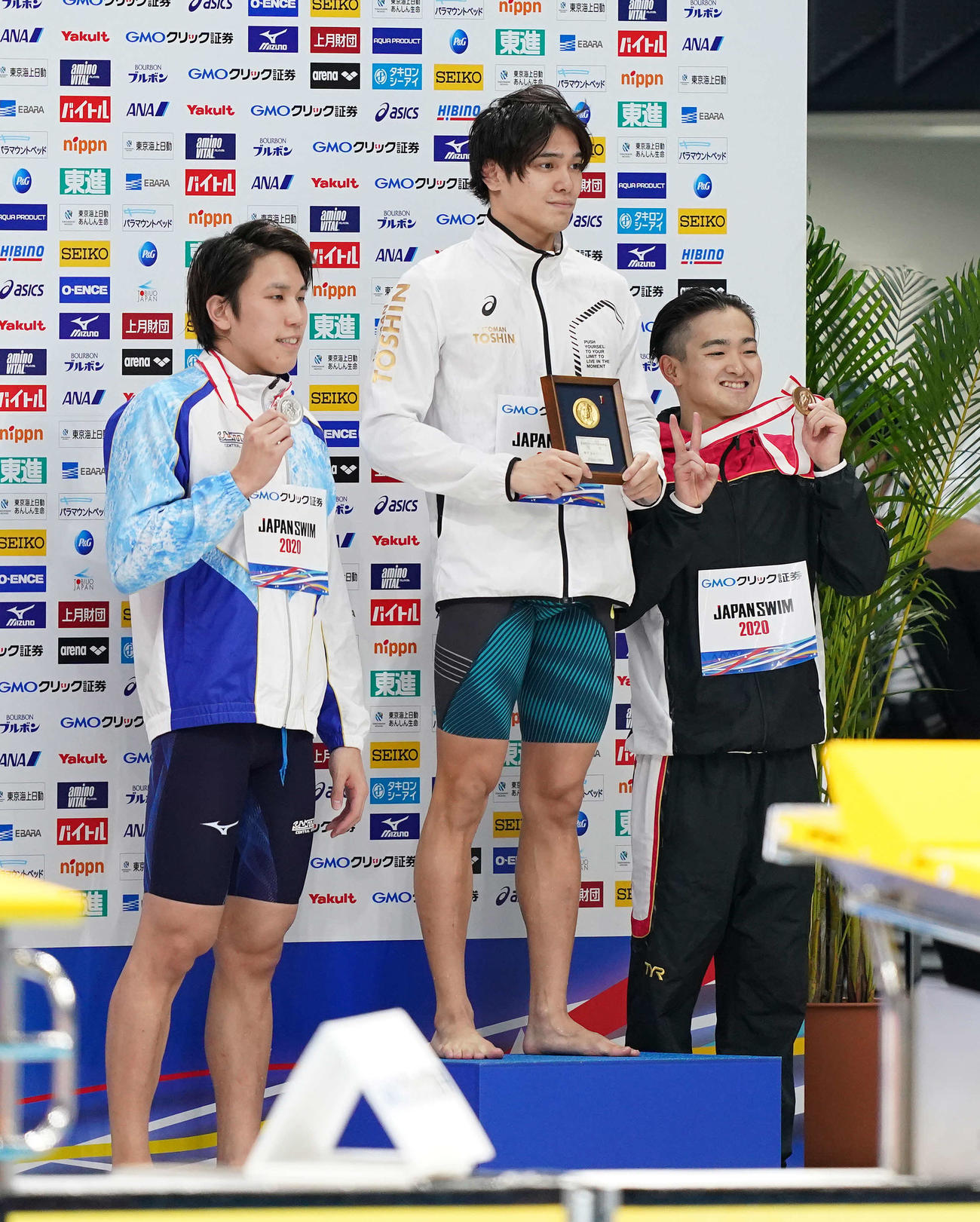 男子100メートル自由形で優勝し、表彰台で笑顔の中村（中央）。左は2位の松元、右は3位の関（撮影・鈴木みどり）