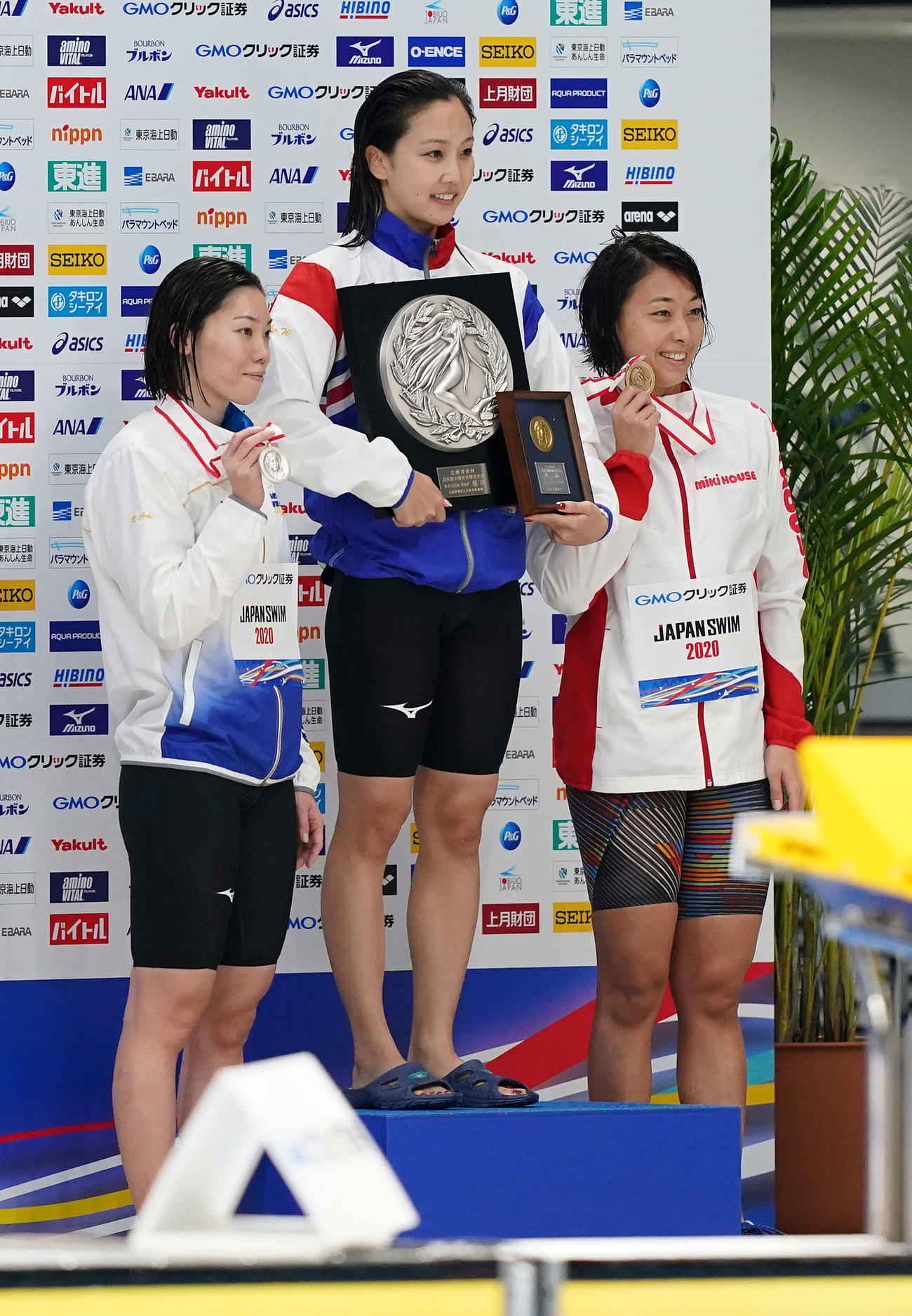女子100メートル平泳ぎで優勝し、表彰台で笑顔の渡部（中央）。左は2位の青木、右は3位の鈴木（撮影・鈴木みどり）