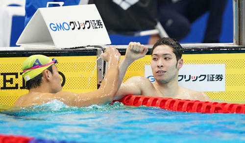 男子400メートル個人メドレーで優勝した萩野（右）は、本多とタッチを交わす（撮影・鈴木みどり）