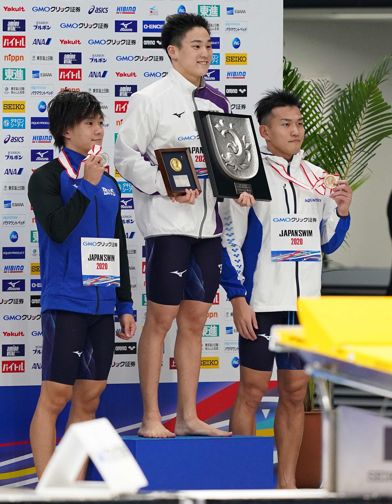 男子100メートル平泳ぎで優勝し、表彰台で笑顔の佐藤（中央）。左は2位の武良、右は3位の日本（撮影・鈴木みどり）