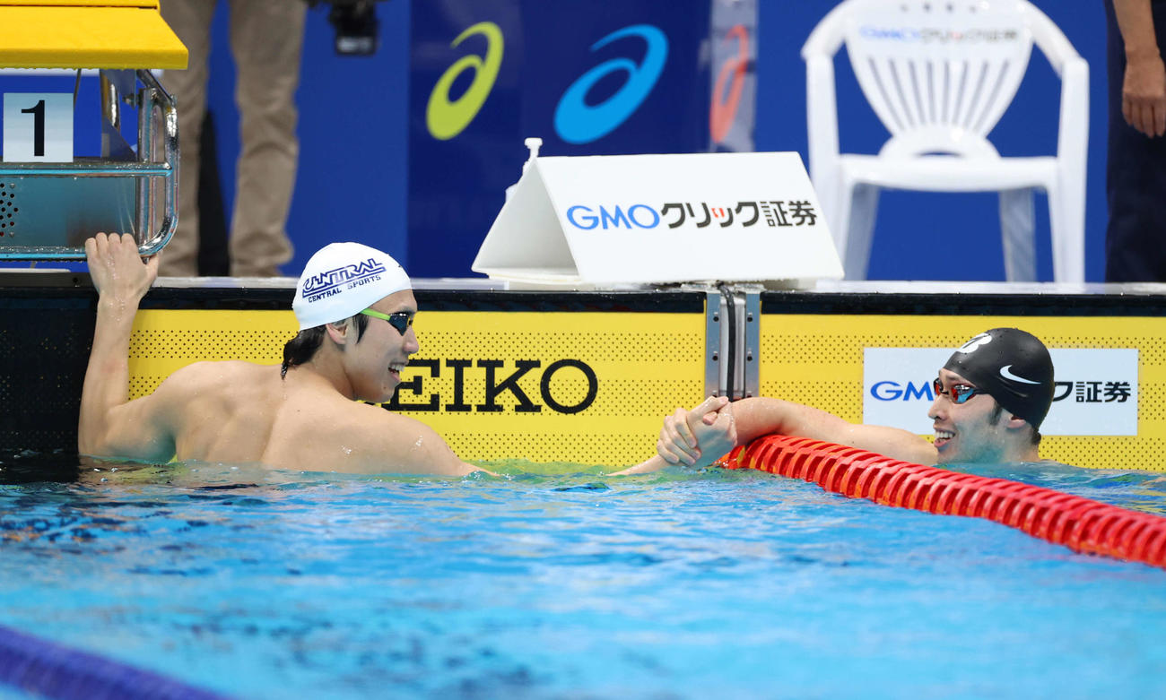 男子100メートル自由形を制した松元（左）は萩野と笑顔で握手を交わす（撮影・河野匠）