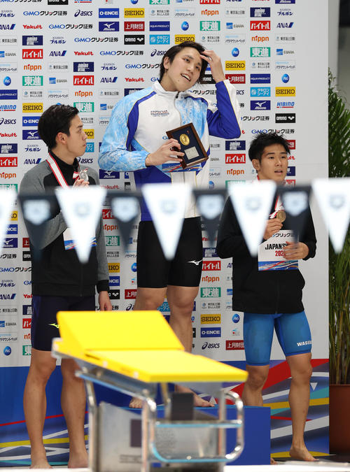 男子200メートル自由形で優勝し記念撮影に臨んだ松元（中央）。左は2位の吉田、右は3位の尾崎（撮影・河野匠）