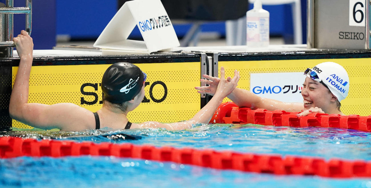 女子100メートル自由形で同着で優勝し、握手する酒井（左）と大本（撮影・鈴木みどり）