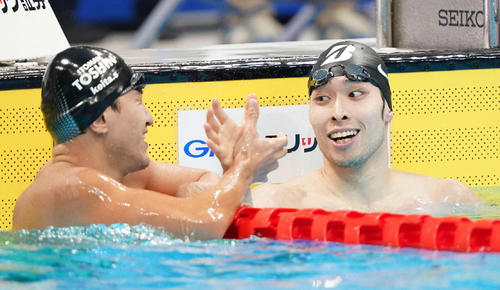 男子200メートル個人メドレーで優勝した萩野（右）は砂間と握手（撮影・鈴木みどり）